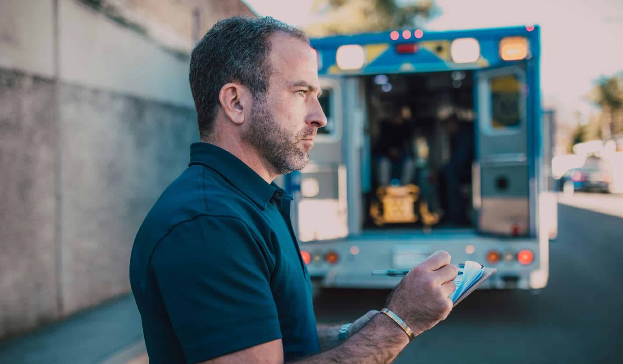 man standing by ambulance assessing risk