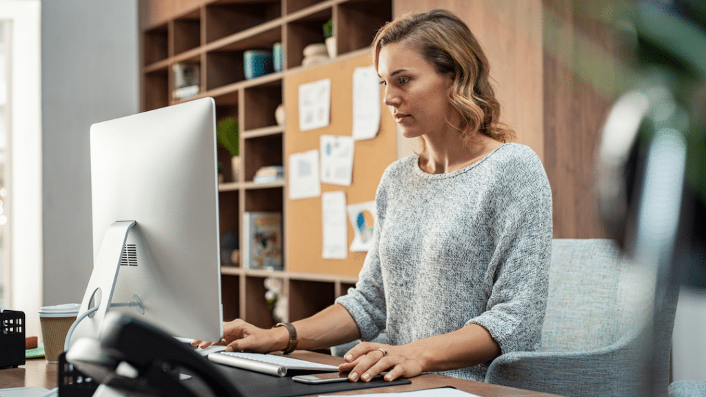Woman working at computer | best healthcare compliance software
