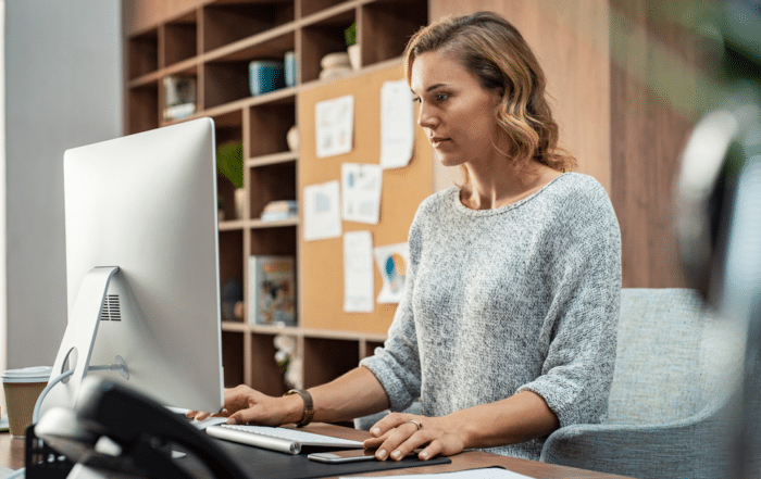 Woman working at computer | best healthcare compliance software
