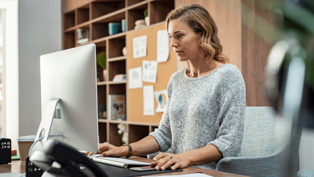 Woman working at computer | best healthcare compliance software